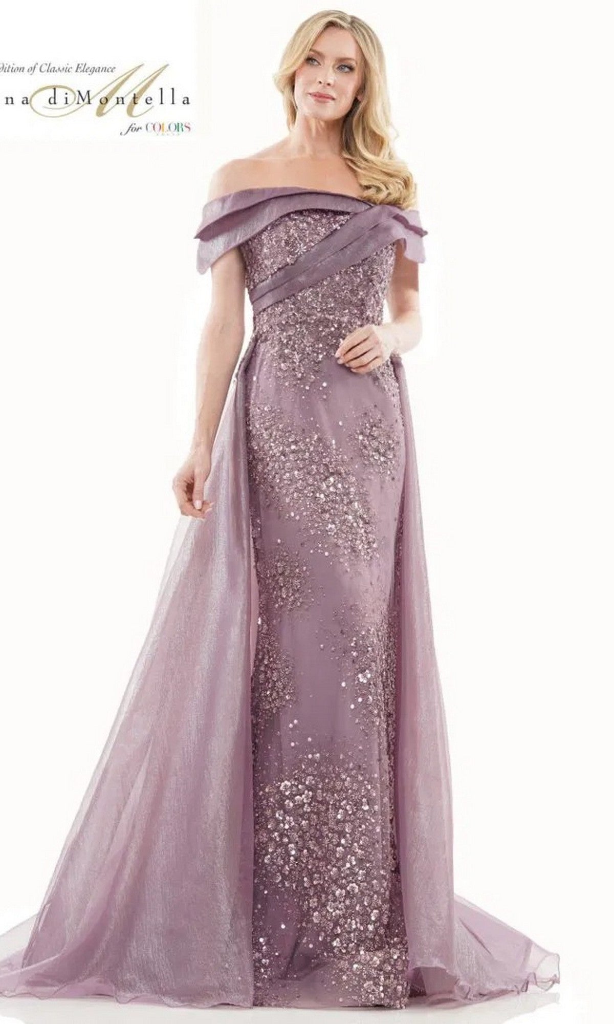 A woman stands facing forward in the Rina Di Montella RD2816 long formal dress, featuring an off-the-shoulder design in Victorian Lilac with sequins and sheer fabric panels.